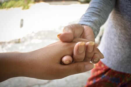 Close up granddaughter takes care of the health sick grandmother at home by holding hands. Lifestyle support the love of the family.の写真素材