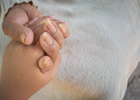 Close up granddaughter takes care of the health sick grandmother at home by holding hands. Lifestyle...