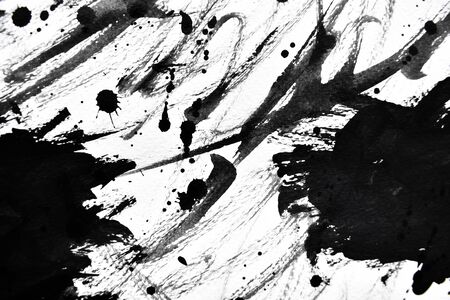 Black ink droplets on white paperの写真素材