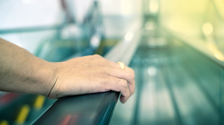 hand of a man holding an escalator at supermarket, take a risk to spread or to get any virusの写真素材