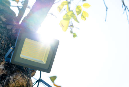 LED spot light and solar panel on tree outside of the building with sunshine.の写真素材