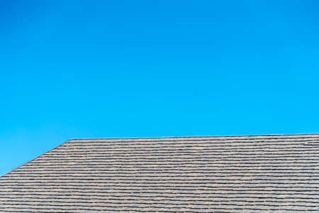 black tile roof on a new house with clear blue sky backgroundの写真素材