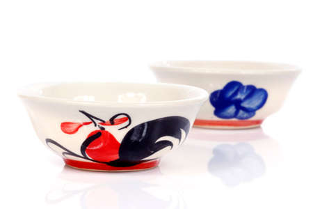 porcelain bowls with painted chicken on white backgroundの写真素材