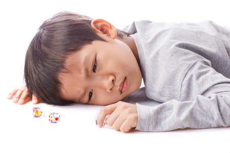 Concentrated boy plays dices on tableの写真素材