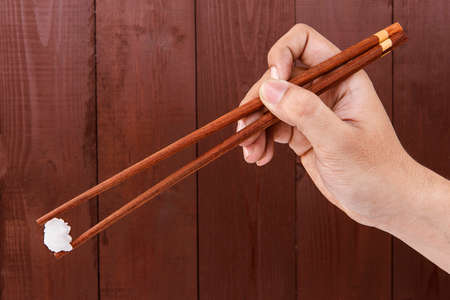 Sea rock salt with chopstick on wood backgroundの写真素材