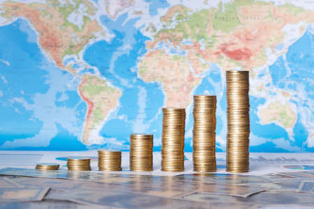 World Business Concept : Grown Up Coin Graph on World Map and US Dollars Background.の写真素材