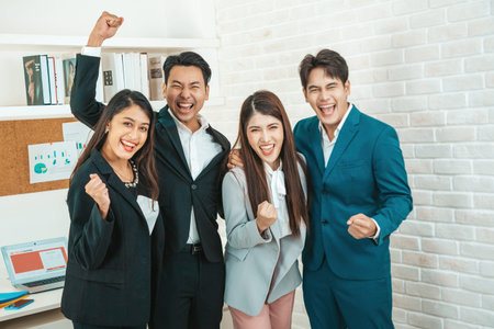 Happy diverse employees team celebrating teamwork success, business achievement at meeting.Group of successful happy business people working as a team in office on meeting.の写真素材