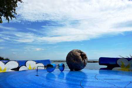 The Sun Glasses and Coconut on the Sea beach with Blue Sky backgroundの写真素材