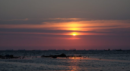 colorful sky sunset sea cargo ship silhouetteの写真素材