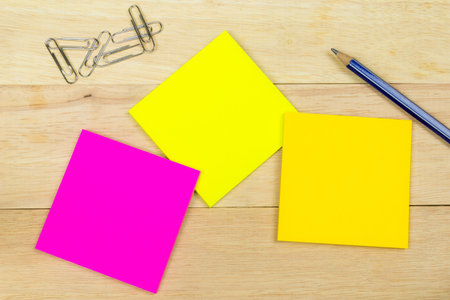 Colorful sticky notes with clips and pen on wood backgroundの写真素材