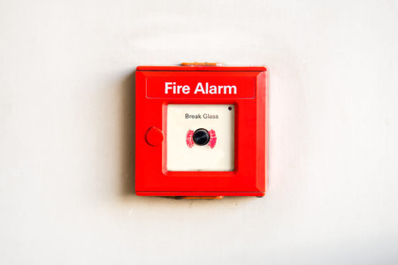 Old red box fire alarm on cement wall. Fire break glass alarm switch on wall background.の写真素材