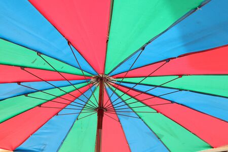 Closeup multicolored bright positive open umbrella top view background.の写真素材