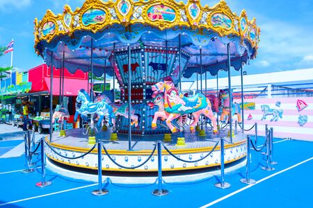 Carousel ride spins fast in the air at sunset - vintage filter effects - a swinging carousel fair ride in amusement park at duskの写真素材