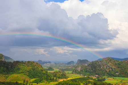 Picturesque view of beautiful rainbow over mountains