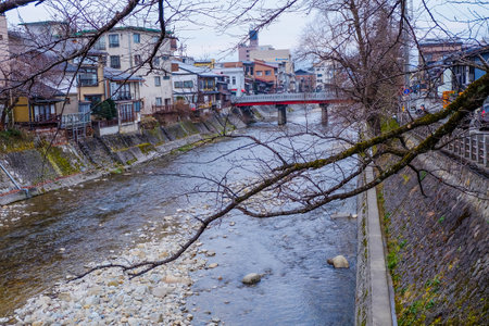 Red Nakabashi Bridge across Miyagawa river with tourist in winterの写真素材