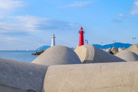 The old red and white lighthouses built on the stone seashoreの写真素材