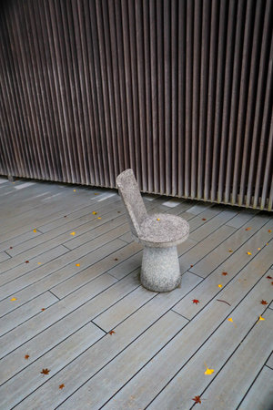 Minimalist Outdoor Seating with Reflections on a Wet Surface Surrounded by Natureの写真素材