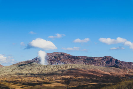 Volcanic Landscape of Mount Aso with Smoking Crater and Rugged Terrain in Japanの写真素材