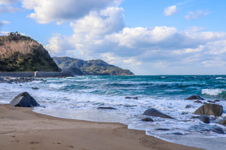 Waves Crashing Against Coastal Boulders on Windy Dayの写真素材