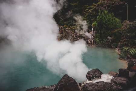 Thick Steam Rising from Natural Volcanic Onsen Pool in Japanの写真素材