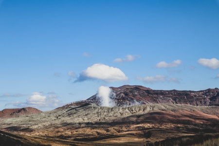 Volcanic Landscape of Mount Aso with Smoking Crater and Rugged Terrain in Japanの写真素材