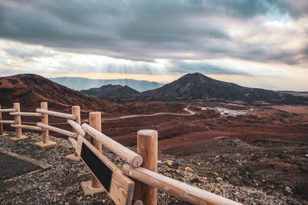 Scenic View of Mountain Landscape with Sun Rays and Wooden Fence at Sunsetの写真素材