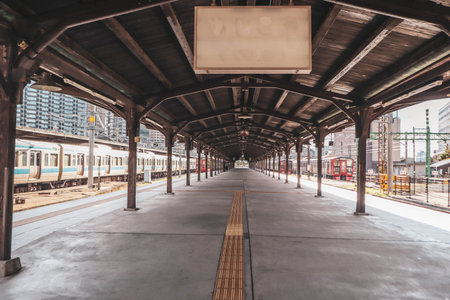 Vintage Japanese Railway Platform at Mojiko Station with Blue Train and Retro Roof Design