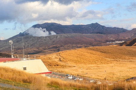 Volcanic Landscape Viewpoint with Observation Deck and Cars in Dry Grassland, Japanの写真素材