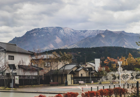 Scenic Kyushu Landscape of Rural Town and Volcanic Mountains Under Cloudy Skyの写真素材