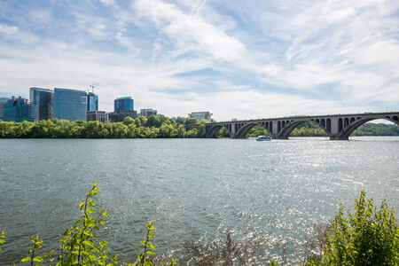 view of bridge over the river with tree and buildings and blue sky with cloud in the backgroundの写真素材