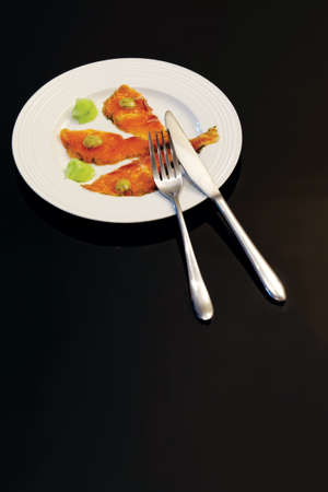 Gravlax with cucumber salad, white plate on dark glass