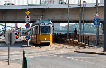 Budapest, Hungary - March 08, 2017: Yellow tram stopped near crossroad on Jane Haining street placed along Danube river with Erzsebet and Liberty bridges on the backgroundのeditorial素材