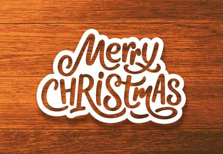 Merry Christmas text on paper label with hand lettering over wood background. Sticker or greeting card vector design template for Xmas celebrationのイラスト素材