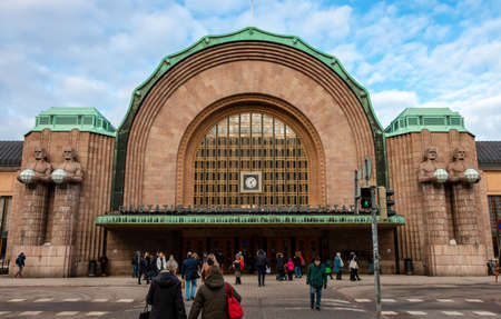 Helsinki, Finland - February 18, 2019: Central railway station exterior front view. People walking near entrance of Rautatieasema Jarnvags Stationのeditorial素材