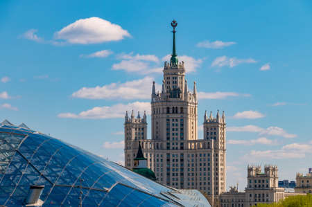 Moscow, Russia - April 29, 2019: Cityscape with soviet skyscraper on Kotelnicheskaya embankment and glass dome in the park Zaryadyeのeditorial素材
