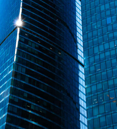 Reflection on glass facades of modern skyscraper in sunny day. Concept of business background with...