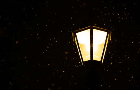 Christmas scene with lantern and falling snow at night. Winter holiday seasonの写真素材