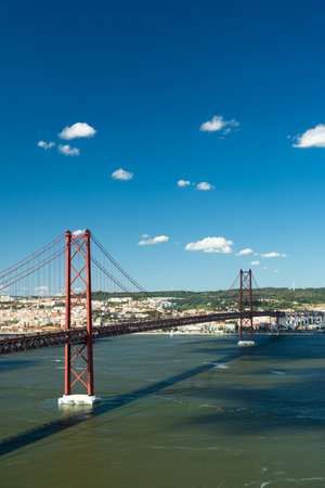 25th of April Bridge and Tagus River. Ponte 25 de Abril Suspension Bridge and Lisbon Skyline. Blue Sky. Portugalの写真素材
