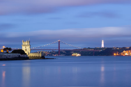 Illuminated Belem Tower, 25th of April Suspension Bridge, Cristo Rei Monument and Tagus River at Evening Twilight. Lisbon, Portugal. Blue Hourの写真素材
