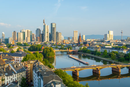 Frankfurt City Skyline, Residential Buildings, Bridges and Barge on Main River on Sunny Morning. Wide Shot. Aerial View. Golden Hour. Hesse, Germanyの写真素材