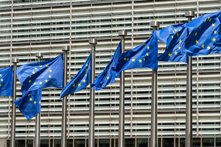 Row of European Union Blue Flags and Berlaymont Building, Headquarters of the European Commission. City of Brussels, Belgiumの写真素材