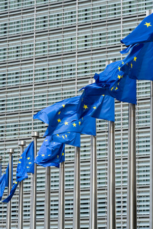 Row of European Union Blue Flags and Berlaymont Building, Headquarters of the European Commission....