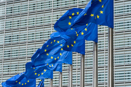 Row of European Union Blue Flags and Berlaymont Building, Headquarters of the European Commission....