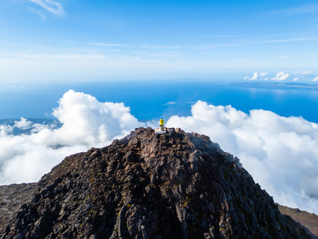 Man on Top of Mount Pico above Clouds on Sunny Day. Summit and Atlantic Ocean. Pico Island, Azores. Portugal. Aerial Viewの写真素材