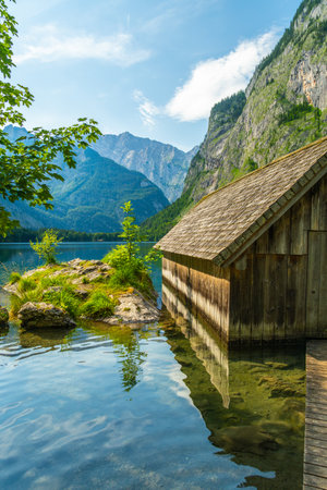 Obersee Lake, Fischunkelalm Wooden Cabin, Tree Branches and Mountains on Sunny Summer Day. Bavarian Alps. Bavaria, Germanyの写真素材