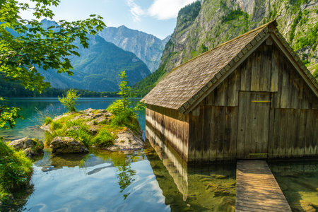 Obersee Lake, Fischunkelalm Wooden Cabin, Tree Branches and Mountains on Sunny Summer Day. Bavarian Alps. Bavaria, Germanyの写真素材