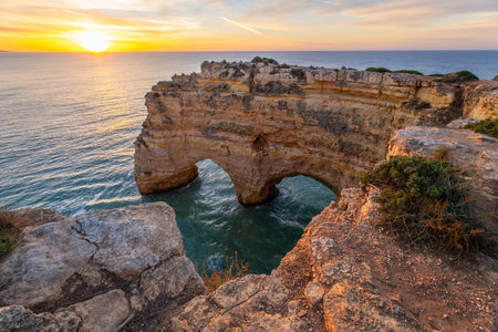 Heart of the Algarve Rock Formation near Marinha Beach. Cliffs and Atlantic Ocean at Sunrise. Golden Hour. Algarve, Portugalの写真素材