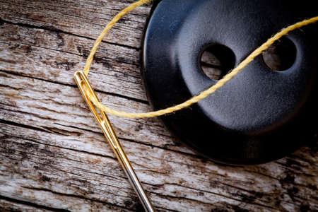 button with needle - tailoring - close upの写真素材