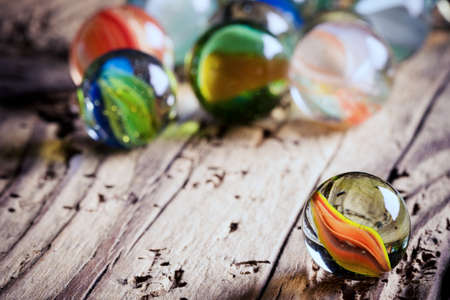 glass marbles on wood - close upの写真素材