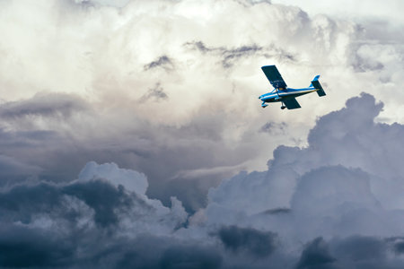 airplane in the clouds in stormy skyの写真素材